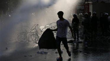 A Lebanese activist carries a plastic bag of garbage as he sprayed by water cannons, during a protest against the ongoing trash crisis (AP)