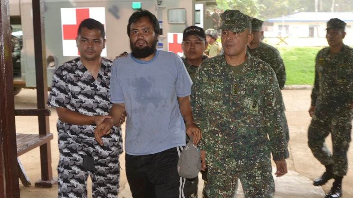 Escaped hostage Philippine coast guard Seaman First Class (SN1) Rod Pagaling, center, is escorted inside a military camp in Jolo, Sulu province, southern Philippines Thursday, Aug. 20, 2015.