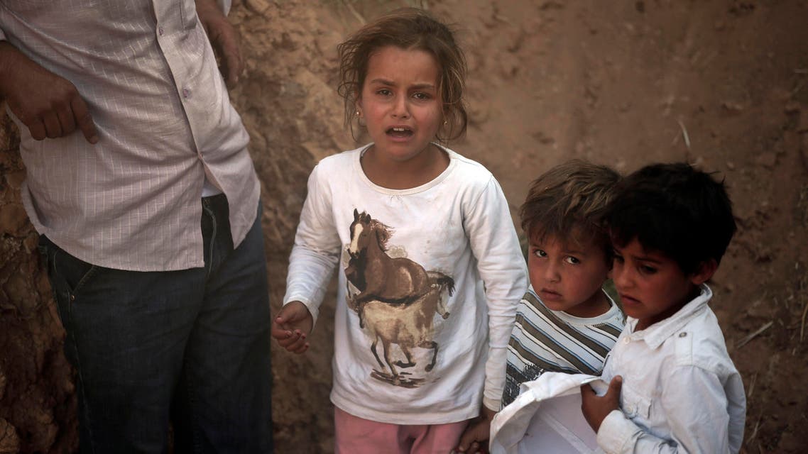 Syrian refugee children are stuck after breaking the border fence and crossing into Turkey from Syria, in Akcakale, Sanliurfa province, southeastern Turkey, Sunday, June 14, 2015. AP