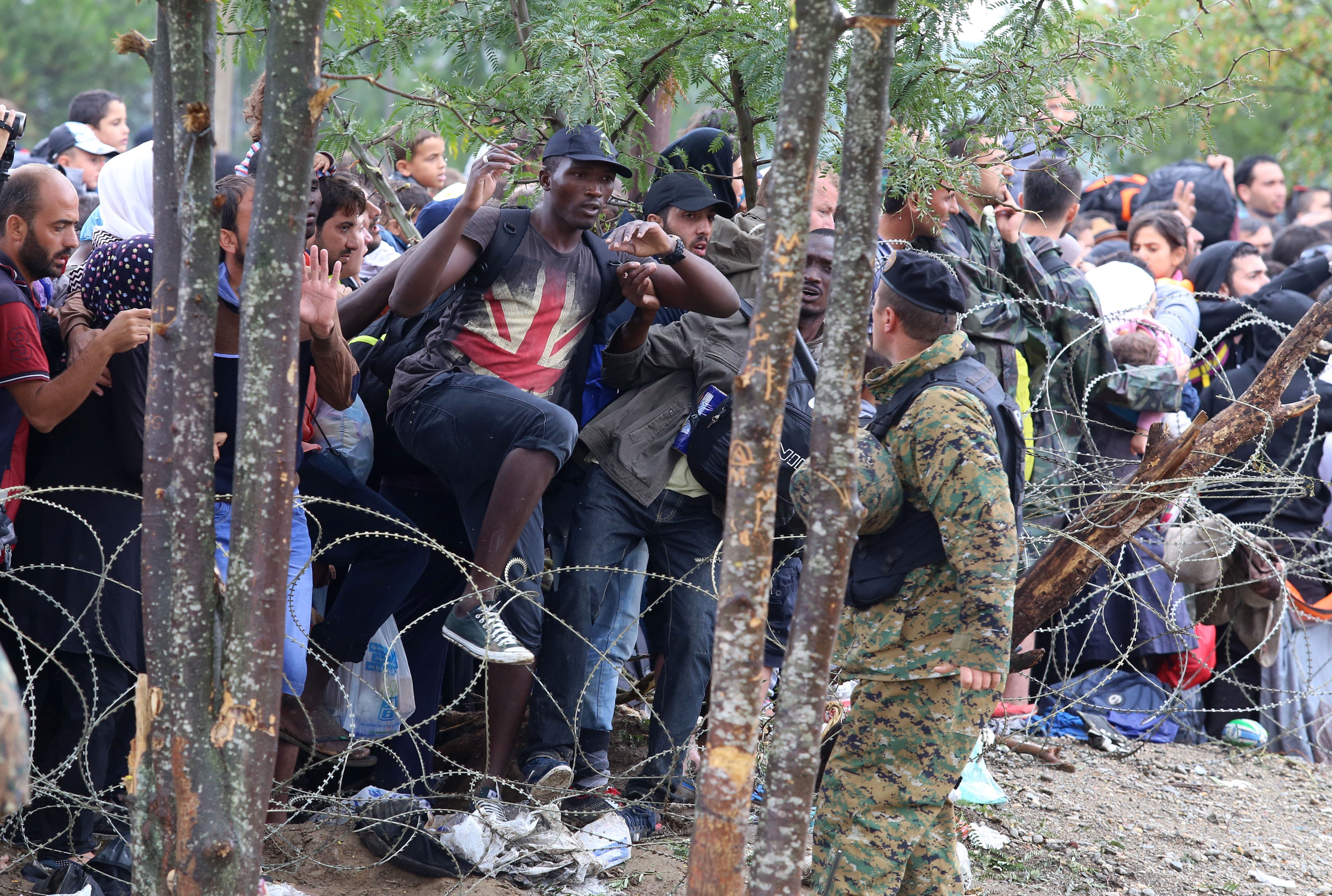 Migrants break the police blockade to enter into Macedonia from Greece, on the border line between the two countries, near the southern Macedonia's town of Gevgelija, on Saturday, Aug. 22, 2015. (AP)