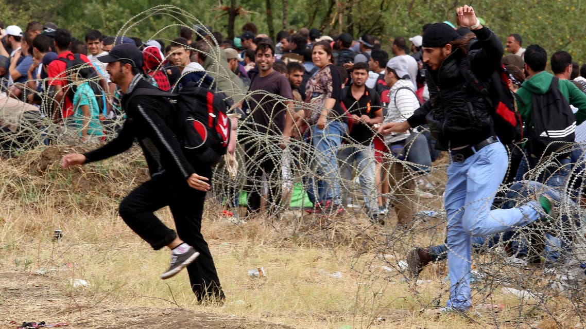 Migrants break the police blockade to enter into Macedonia from Greece, on the border line between the two countries, near the southern Macedonia's town of Gevgelija, on Saturday, Aug. 22, 2015. (AP)