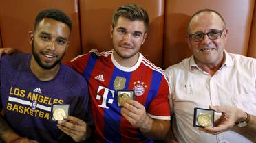Sadler, Sharlatos, and Norman, three men who helped to disarm an attacker on a train from Amsterdam to France, pose with their medals at a restaurant in Arras, France. (Reuters)