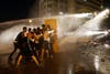 Lebanese activists shout anti-government slogans as they are sprayed by riot police using water cannons during a protest against the ongoing trash crisis, in downtown Beirut, Lebanon, Sunday, Aug. 23, 2015.  (AP)