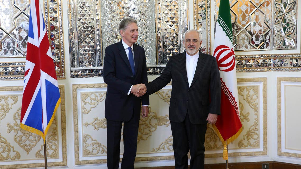 Iranian Foreign Minister Mohammad Javad Zarif, right, and British Foreign Secretary Philip Hammond, shake hands for media prior to their meeting in Tehran, Iran, Sunday, Aug. 23, 2015. British Foreign Secretary Philip Hammond reopened the British Embassy in Tehran on Sunday, nearly four years after it was closed following an attack by hard-liners. (AP Photo/Vahid Salemi)