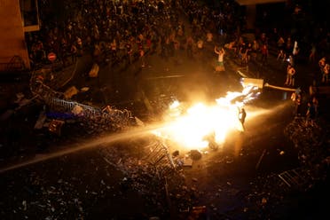 Lebanese protesters set a police motorcycle on fire as they are sprayed by riot police using water cannons during a protest against the ongoing trash crisis, in downtown Beirut, Lebanon, Sunday, Aug. 23, 2015.  (AP)