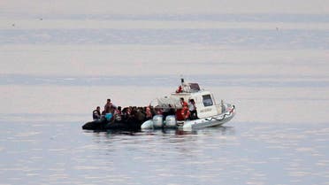 Turkish Coast Guard officers on a boat capture migrants from the coastal town of Bodrum, Turkey, headed to the Greek island of Kos, on Saturday, Aug. 15, 2015. AP