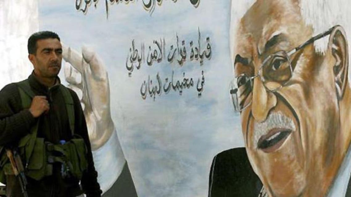 A Fatah movement member stands next to a mural of the Palestinian leader Mahmud Abbas in the Ain al-Hilweh Palestinian refugee camp on the outskirts of the southern Lebanese city of Sidon. (AFP/File)