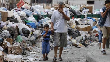 Residents cover their noses as they walk past garbage piled up along a street in Beirut, Lebanon August 26, 2015. (Reuters)
