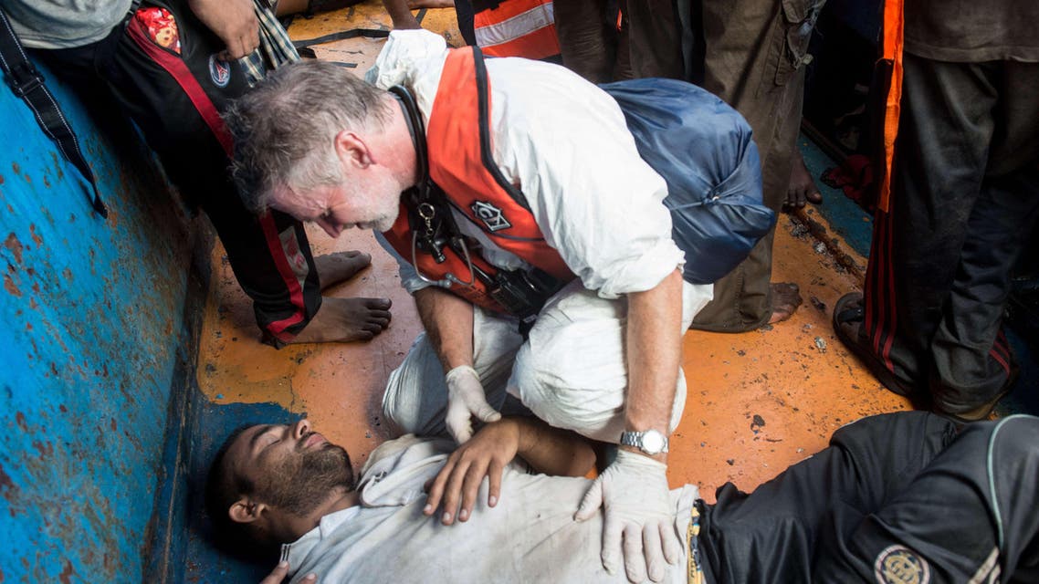 ITA12505 - -, MEDITERRANEAN SEA, - : In this handout picture released by the French NGO Medecins Sans Frontières (Doctors without borders - MSF) on August 27, 2015 a doctor gives medical assistance to a migrant in a wooden boat during a rescue operation by MSF and the Swedish Coast Guards "Poseidon" in the Meditterranean sea. At least 55 dead bodies were discovered during this operation on August 26, 2015 on three overcrowded migrant boats in the Mediterranean, the Italian coastguard said. Almost all of the victims -- 51 -- were found in the hold of a wooden boat found drifting precariously off the Libyan coast by Swedish coastguard vessel the Poseidon. Media reports said they had choked to death on gas fumes from the small motor boat. AFP PHOTO / GABRIELE FRANCOIS CASINI / MEDECINS SANS FRONTIERES