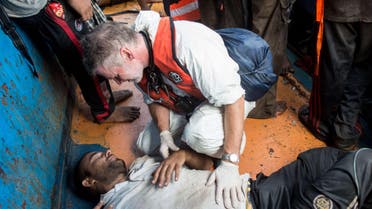  ITA12505 - -, MEDITERRANEAN SEA, - : In this handout picture released by the French NGO Medecins Sans Frontières (Doctors without borders - MSF) on August 27, 2015 a doctor gives medical assistance to a migrant in a wooden boat during a rescue operation by MSF and the Swedish Coast Guards "Poseidon" in the Meditterranean sea. At least 55 dead bodies were discovered during this operation on August 26, 2015 on three overcrowded migrant boats in the Mediterranean, the Italian coastguard said. Almost all of the victims -- 51 -- were found in the hold of a wooden boat found drifting precariously off the Libyan coast by Swedish coastguard vessel the Poseidon. Media reports said they had choked to death on gas fumes from the small motor boat. AFP PHOTO / GABRIELE FRANCOIS CASINI / MEDECINS SANS FRONTIERES