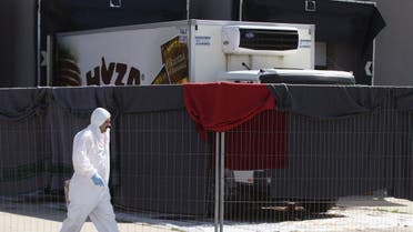 A member of a forensic team walks in front of a truck in which more than 70 bodies were found, at a customs building with refrigeration facilities in the village of Nickelsdorf. (File: Reuters)