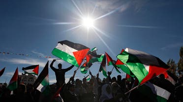  Palestinians wave flags as they celebrate their successful bid to win U.N. statehood recognition in the West Bank city of Ramallah, Sunday, Dec. 2, 2012. The Palestinian President Mahmoud Abbas, not shown, has returned home to a hero's welcome after winning a resounding endorsement for Palestinian independence at the United Nations. Israel on Sunday roundly rejected the United Nations' endorsement of an independent state of Palestine, announcing it would withhold more than $100 million collected for the Palestinian government to pay debts to Israeli companies. (AP Photo/Majdi Mohammed)