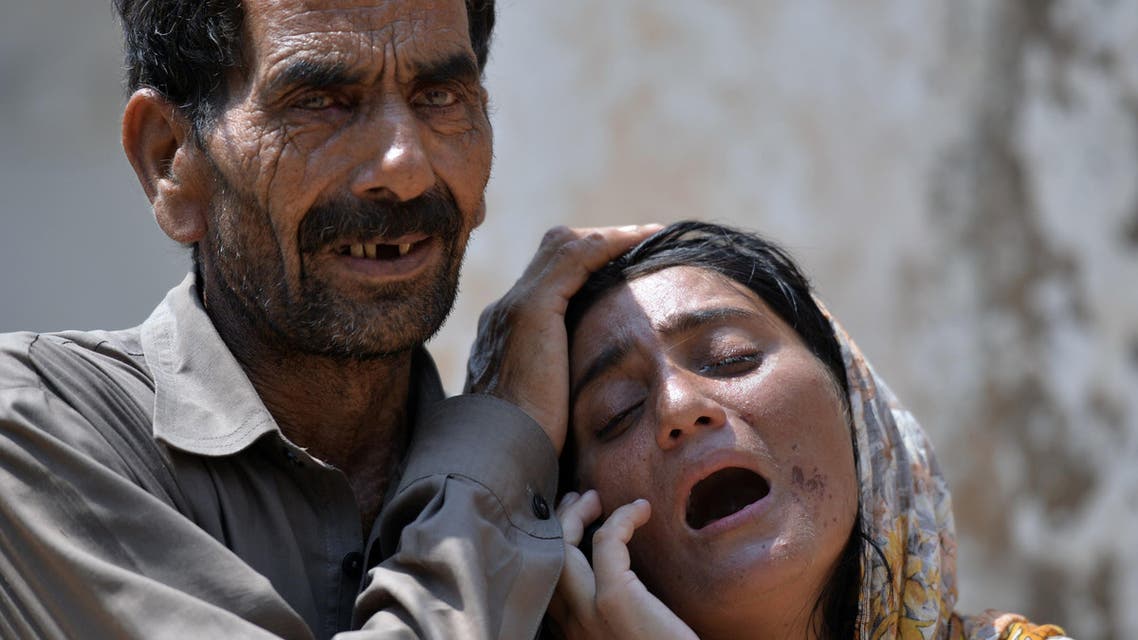 AQ7121 - Kundanpur, -, PAKISTAN : Pakistani woman, Laila (R) is comforted as she mourns the killing of her husband following the cross-border shelling by the Indian Border Security Force (BSF), in Kundanpur on the India-Pakistan border near the eastern city of Sialkot on August 29, 2015. At least 10 civilians were as India and Pakistan traded fire across their disputed border, officials said, less than a week after high-level talks were aborted amid a row over Kashmir. AFP PHOTO / Aamir QURESHI
