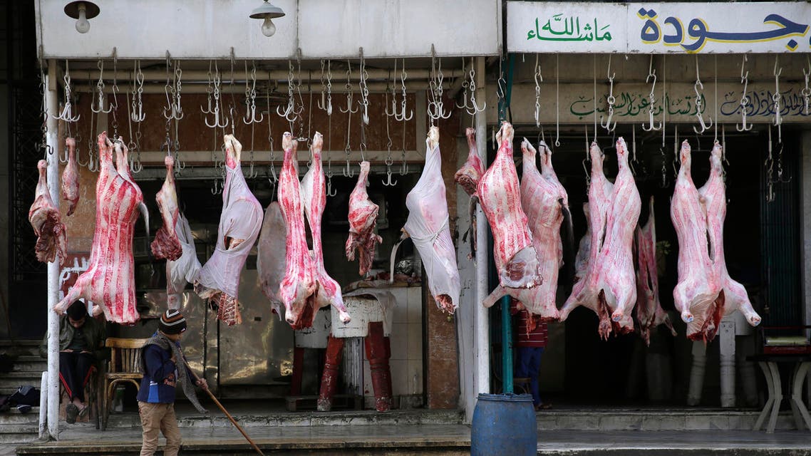  An Egyptian child cleans the street under meat displayed for sale in the Imbabah neighborhood of Giza, Egypt, Thursday, Feb. 26, 2015.(AP Photo/Hassan Ammar)