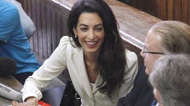 Lawyer Amal Clooney, defending Al Jazeera television journalist's Mohamed Fahmy, talks to Troy Lulashnyk, Canadian Ambassador to Egypt, before hearing the verdict at a court in Cairo, Egypt, August 29, 2015. (Reuters)