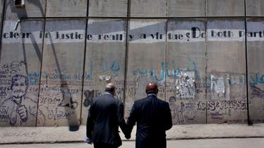 President of the anti-racism campaign Global Watch, Tokyo Sexwale, right, and head of Palestinian Football Association, PFA, Jibril Rajoub inspect the separation barrier on the outskirts of the West Bank city of Ramallah, Thursday, May 7, 2015. AP