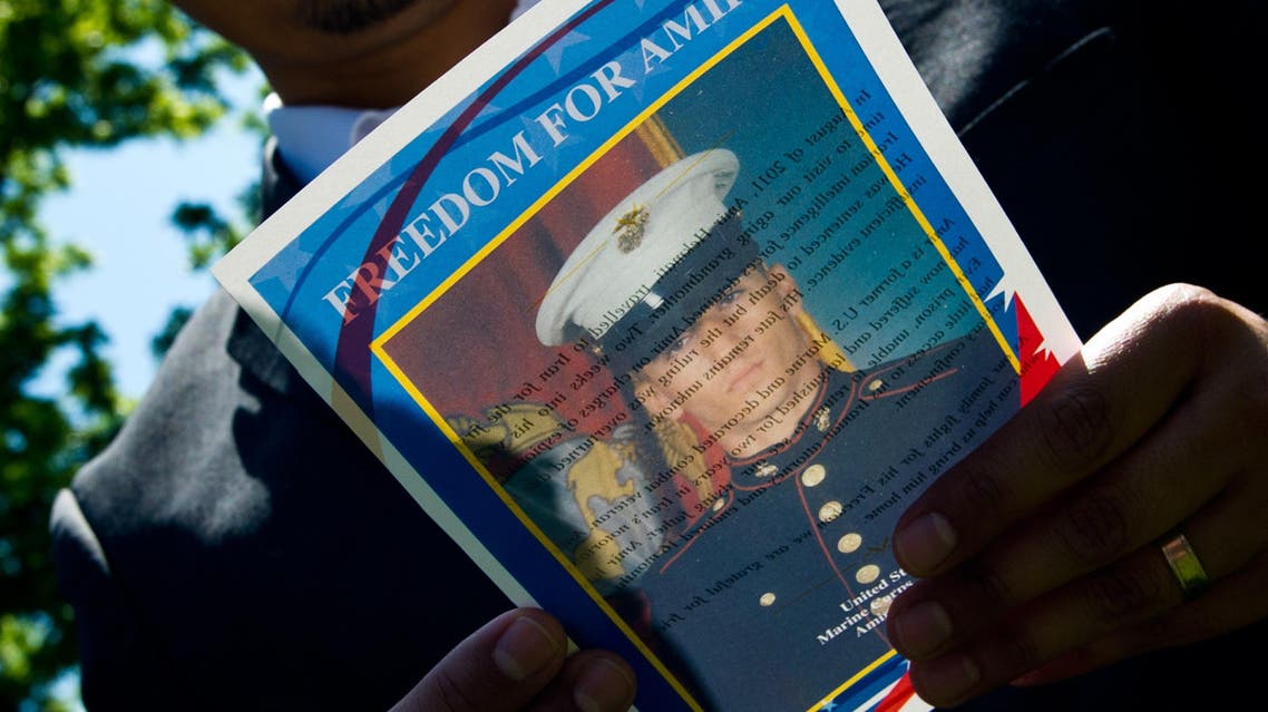 This May 19, 2014 file photo shows a man as he reads a flyer with a photo of US Marine veteran Amir Hekmati during a vigil held in Lafayette Park across from the White House in Washington, DC. US Secretary of State John Kerry on August 28, 2015 urged Iran to free Amir Hekmati, an American who served as a US Marine, from four years of "unjust detention." August 29, 2015 marks the fourth anniversary of Hekmati's imprisonment on what Kerry called "false espionage charges" while Hekmati was visiting relatives in the Islamic republic. "We repeat our call on the Iranian government to release Amir on humanitarian grounds," Kerry said in a statement."This is a milestone no family wants to mark, and the Hekmati family has shown inspiring perseverance in the face of this injustice," he added. AFP PHOTO / Karen BLEIER