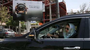 A woman drives in front of an advertising billboard in northern Tehran, Iran, Saturday, July 18, 2015. (AP)