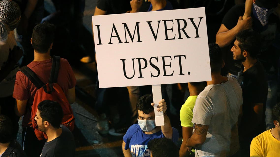 In this Saturday, Aug. 29, 2015 file photo, a Lebanese anti-government protester holds a placard during a demonstration against the on-going trash crisis and alleged government corruption, in Beirut, Lebanon. (AP Photo/Hussein Malla, File)