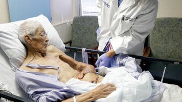 Plastic surgeon Anthony Echo, right, examines Frank Reyes' hand before surgery at Houston Methodist Hospital in Houston on Thursday, Aug. 27, 2015. Reyes, whose hand was badly burned, spent three weeks with his left hand surgically tucked under a pocket of tissue in his belly to give it time to heal and form a new blood supply. (AP Photo/Pat Sullivan)