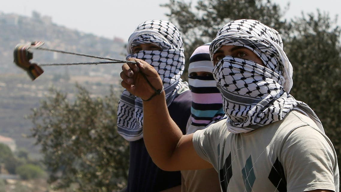 A Palestinian protester hurls rocks towards Israeli security forces during clashes following a demonstration against the expropriation of Palestinian land by Israel on August 28. (AFP)