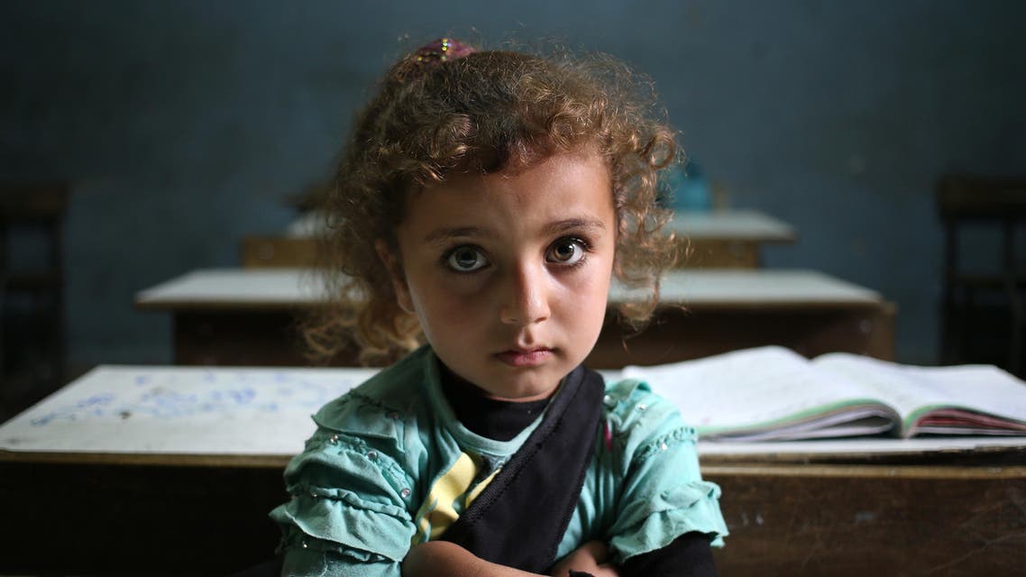 In this Thursday, May 29, 2014 file photo, a Syrian refugee girl sits in a classroom at a Lebanese public school where only Syrian students attend classes in the afternoon, at Kaitaa village in north Lebanon. AP