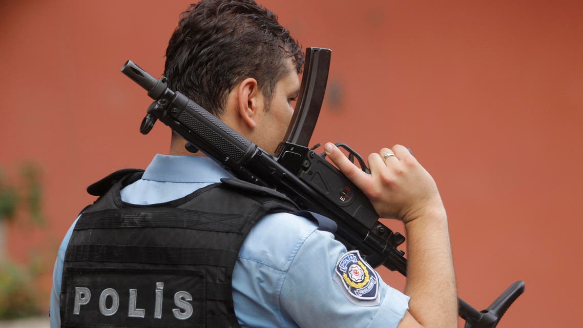 An armed Turkish police officer secures a road leading to the U.S. Consulate building in Istanbul, Monday, Aug. 10, 2015. AP