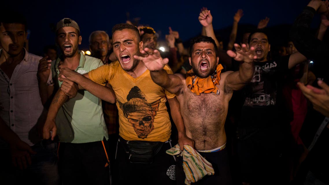 Refugees and migrants take part in a protest demanding the authorities to let them go to Athens and continue their trip towards Northern Europe, at the port of Mytilene, on the northeastern Greek island of Lesbos, on Saturday, Sept. 5, 2015. (AP)