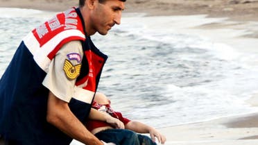 Turkish gendarmerie carries a young migrant, who drowned in a failed attempt to sail to the Greek island of Kos, in the coastal town of Bodrum, Turkey, September 2, 2015. REUTERS