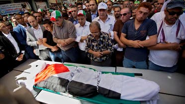 Palestinians prays by the body of Saed Dawabsheh, 32, during his funeral procession in the West Bank village of Duma near Nablus on Saturday, Aug. 8, 2015. (AP)