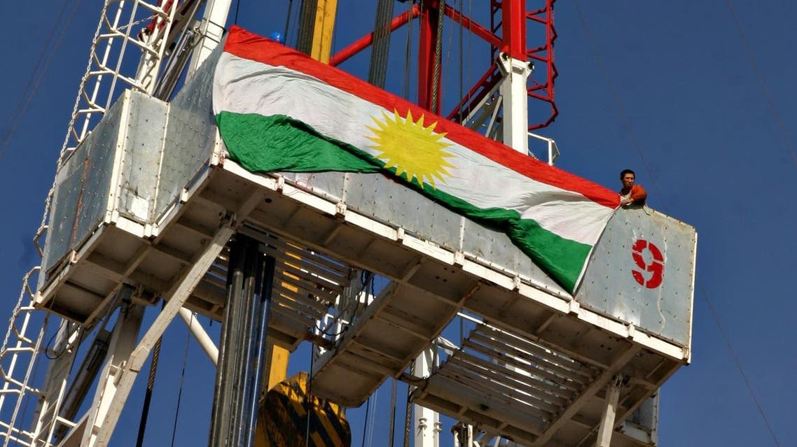A Chinese worker hangs the flag of the Kurdistan Regional Government atop the drill of Norwegian Public Oil company DNO, that started drilling for oil in Iraqi Kurdistan, near Zakho, Nov. 29, 2005. (File photo: AP)
