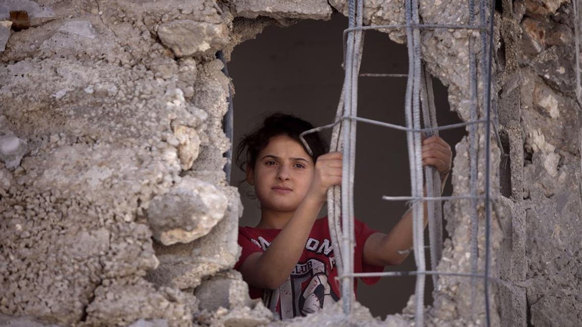 Mai Awad looks out from the damaged family home of Palestinian Ziad Awad in the town of Idna,13 kilometers (8 miles) west of the West Bank city of Hebron, Wednesday, July 2, 2014.
