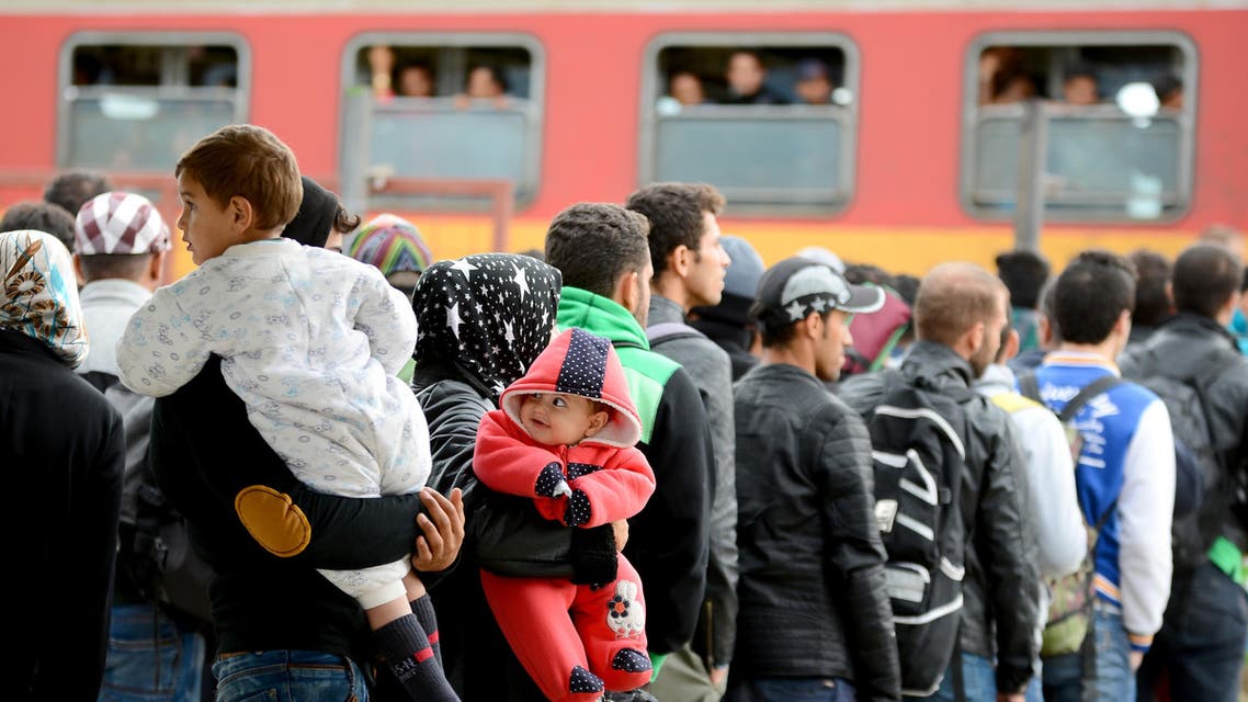 People stand in a queue as they prepare to leave by train from the southern Macedonian town of Gevgelija,Tuesday, Sept. 8, 2015. Hundred of thousands migrants and refugees trying to reach the heart of Europe via Turkey, Greece, the Balkans and Hungary have faced dangers, difficulties and delays on every link of the journey. (AP Photo/Borce Popovski)
