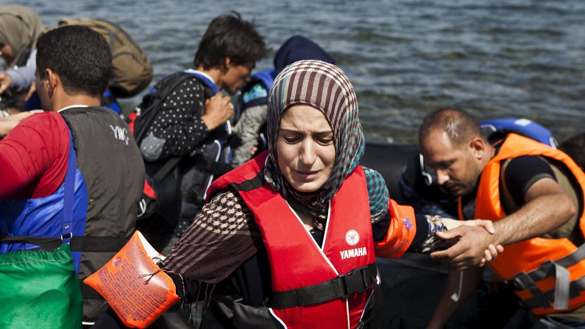 A Syrian refugee wearing a life jacket and armbands reacts moments after arriving on a dinghy on the Greek island of Lesbos. (Reuters)