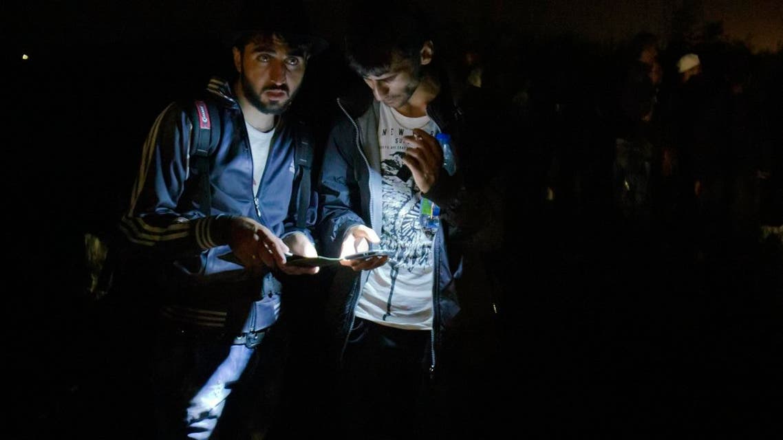 Refugees try to navigate their way using smartphones as they cross the border from Serbia. AP