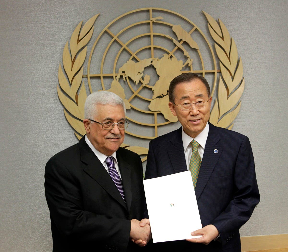 Palestinian President Mahmoud Abbas, left, poses for a picture with Secretary-General Ban Ki-moon after giving him a letter requesting recognition of Palestine as a state during the 66th session of the General Assembly at United Nations headquarters Friday, Sept. 23, 2011.