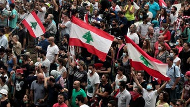 Lebanese anti-government protesters shout slogans as they hold their national flags, during a protest against the on-going trash crisis and government corruption, in downtown Beirut. (AP)