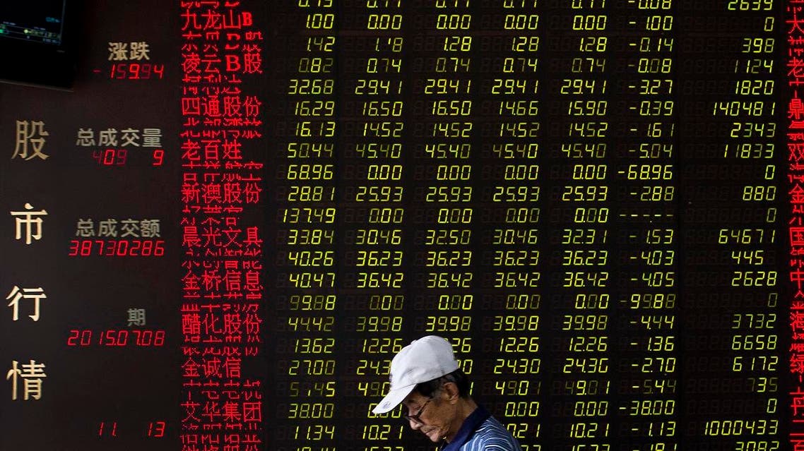 A man walks past an electric board displaying stock prices at a brokerage house in Beijing. (AP)