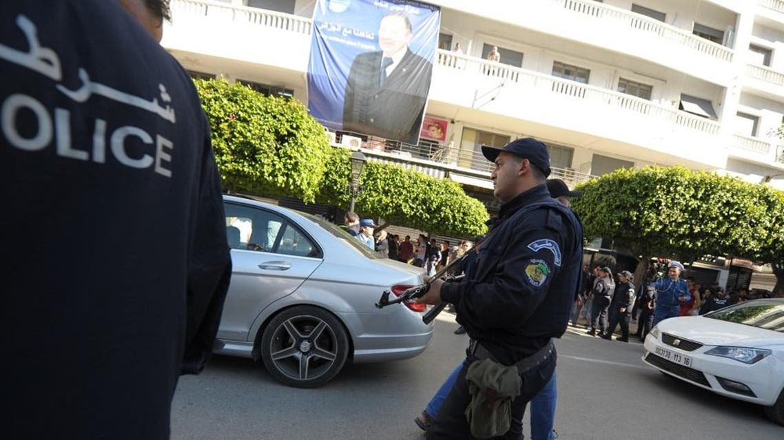 An Algerian police officers take to the streets in an attempt to arrest activists protesting against president Abdelaziz Bouteflika running for a fourth term in Thursday's elections in Algiers Wednesday, April 16, 2014. President since 1999, Abdelaziz Bouteflika,77, is running for a 4th term despite being hit by a stroke last year that left him speaking and moving with difficulty. Six candidates are running for the powerful presidency in the April 17 elections. An election poster of Abdelaziz Bouteflika is seen on the background. (AP Photo/Sidali Djarboub)