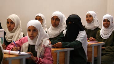 Yemeni girls listen to a teacher, unseen, in a class at a school on the first International Day of the Girl Child, in Sanaa,