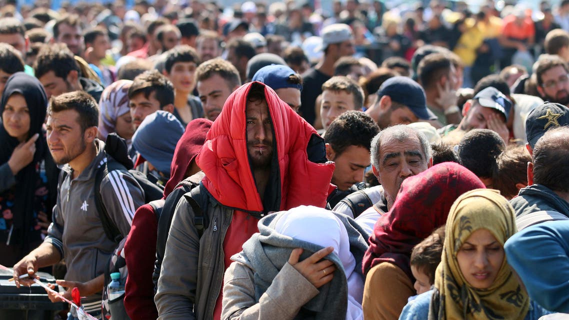 Migrants and refugees waiting for buses after crossing the border between Hungary and Austria in Nickelsdorf, Austria 70 kilometers (43 miles) southeast of Vienna, Sunday, Sept. 13, 2015. (AP Photo/Ronald Zak)