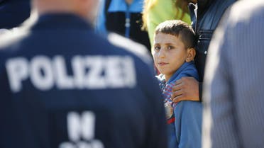 A migrant boy waits for a bus at the crossing point between Hungary and Austria in Nickelsdorf, September 12, 2015.