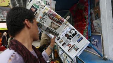 In this Aug. 1, 2015 file photo, an Afghan reads local newspapers carrying headlines about the new leader of the Afghan Taliban, Mullah Akhtar Mansoor, and former leader Mullah Mohammad Omar who was declared dead, on display at a newsstand in Kabul, Afghanistan. 
