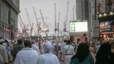 Muslim pilgrims walk towards the Grand Mosque in the holy city of Makkah, Saudi Arabia, marked by towering cranes used in the ongoing expansion. (AP)