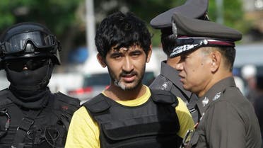 Police officers escort a key suspect in last month's Bangkok bombing, yellow shirt, identified by Thai police as Yusufu Mierili. (File photo: AP)