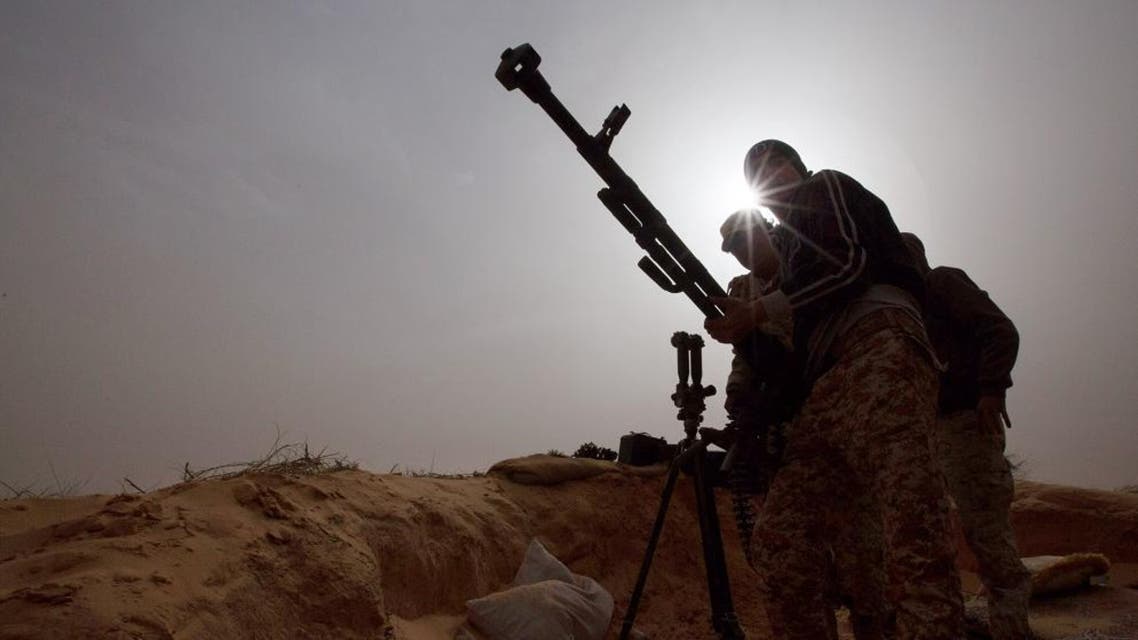 In this Saturday, Feb. 21, 2015 photo, Libyan soldiers try to fix a weapon that jammed during clashes with militants on the frontline in Al Ajaylat, 120 kilometers (75 miles) west of Tripoli, Libya. Army forces in Libya have been fighting Islamic and tribal militias since last September. (AP Photo/Mohamed Ben Khalifa)