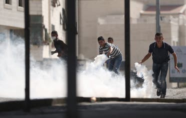 Palestinians prepare to return tear gas canisters fired by Israeli troops during clashes at a protest against an Israeli police raid on September 15, 2015. (Reuters/Mohamad Torokman TPX)