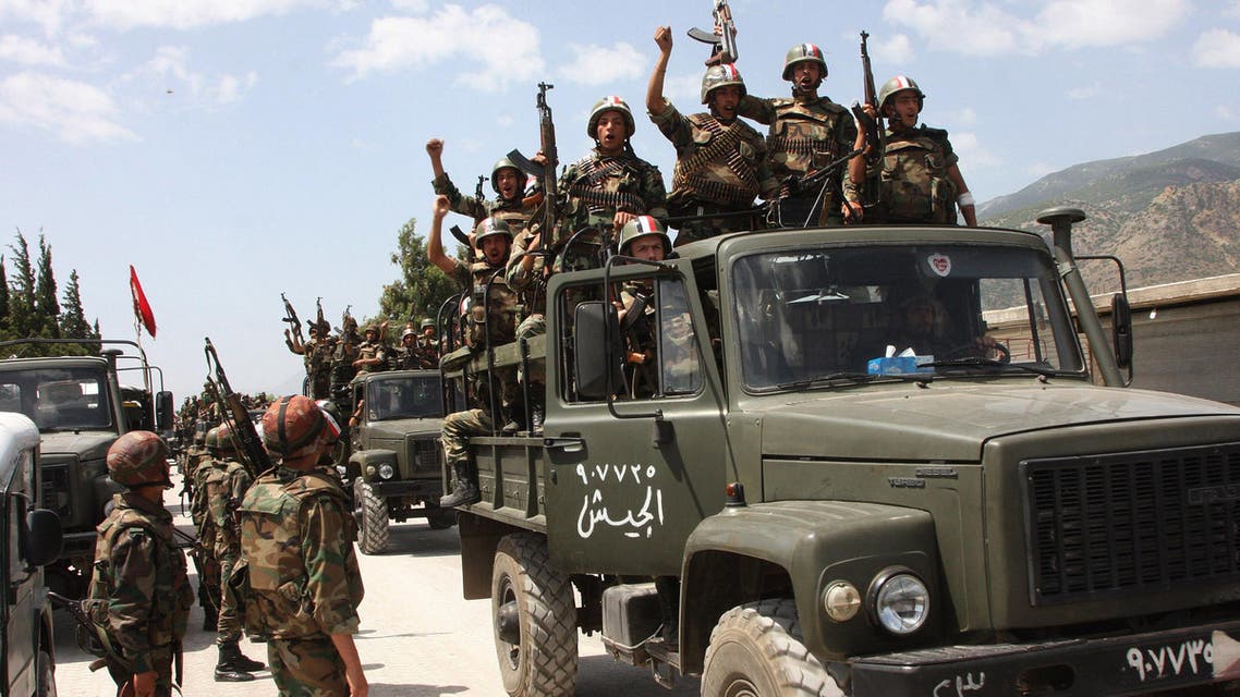 n this June 10, 2011, file photo, taken during a government-organised visit for media, Syrian army soldiers standing on their military trucks shout slogans in support of Syrian President Bashar Assad