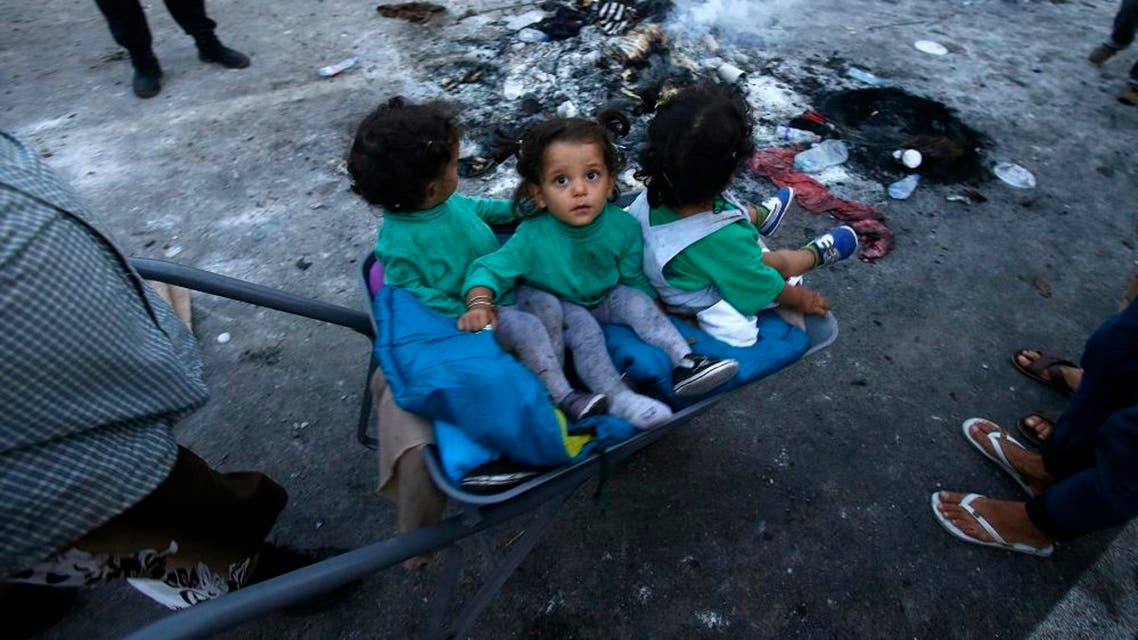 A migrant pushes a wheelbarrow with children at the "Horgos 2" border crossing into Hungary. (AP)