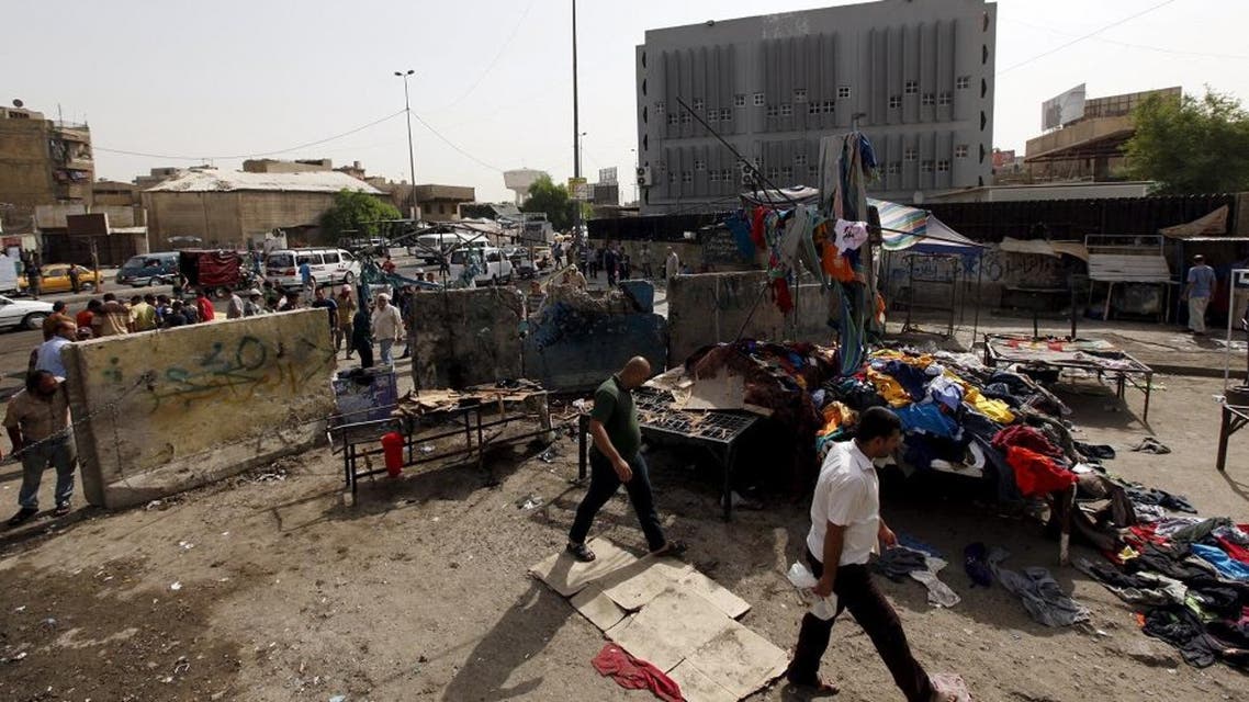 Men walk past the site of a suicide bomb attack in Baghdad. (Reuters)